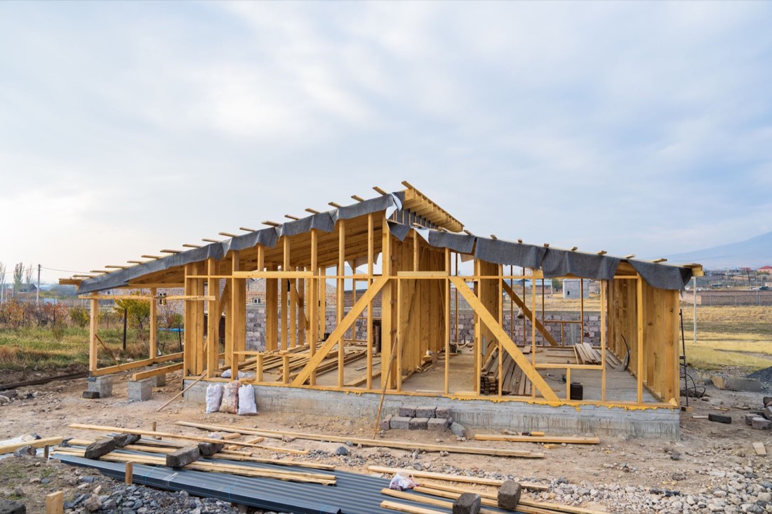 New wood-frame construction under a cloudy sky